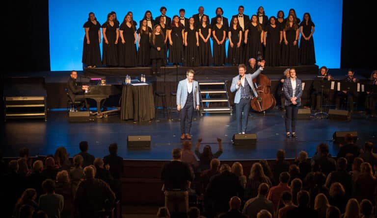 On-stage performance with vocalists, pianist, string musicians, and chrior